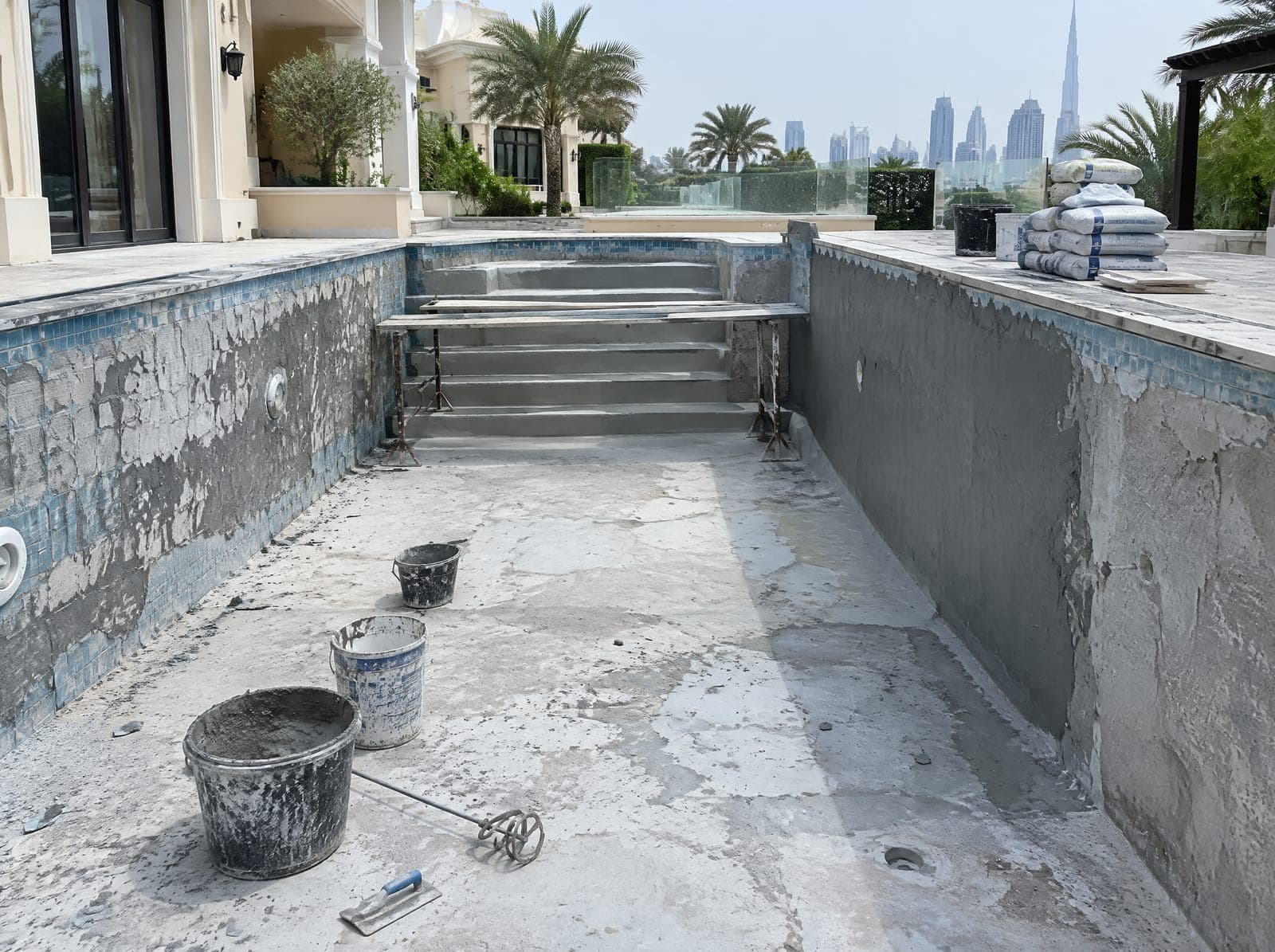 Drained pool during renovation with old tiles removed and fresh waterproofing